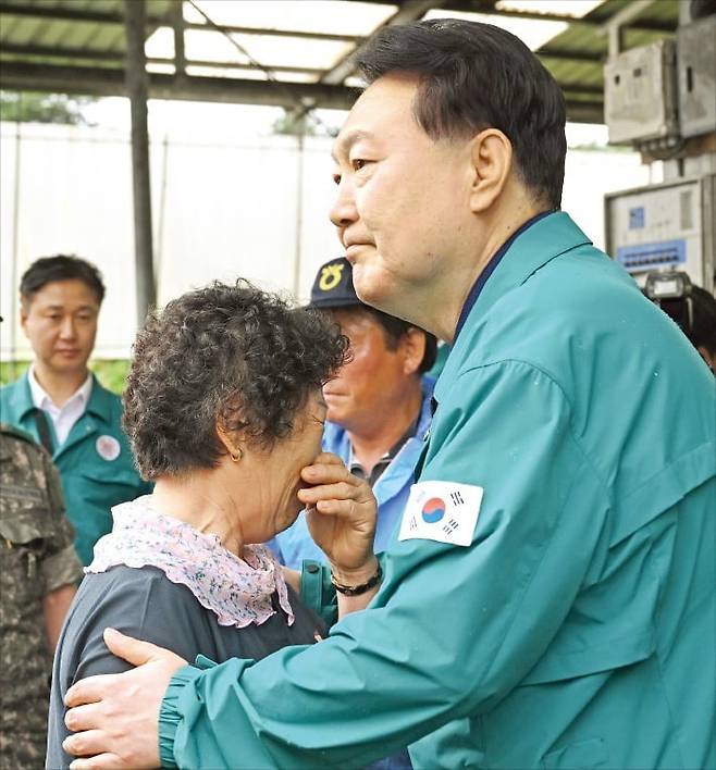 < 피해 주민 위로하는 尹 > 윤석열 대통령이 18일 집중호우 피해 지역인 충남 공주의 한우 축산농가를 찾아 피해 주민을 위로하고 있다.  대통령실 제공