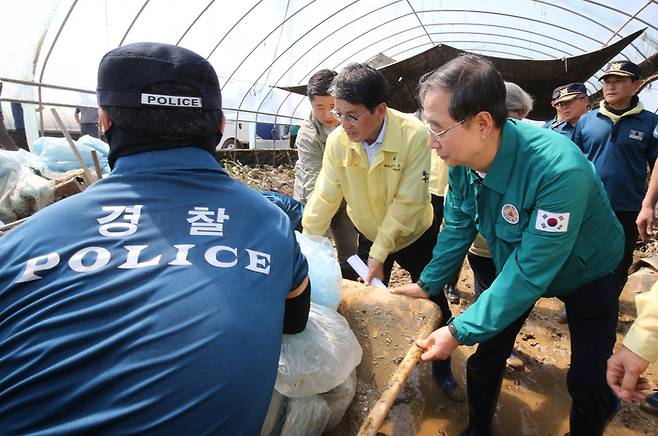 한덕수 국무총리가 19일 오전 특별재난지역으로 선포된 충남 청양군 청남면 인양리를 찾아 복구작업을 돕고 있다. <연합뉴스>