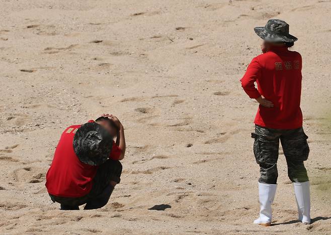 19일 오전 경북 예천군 호명면서 수색하던 해병대원 1명이 급류에 휩쓸려 실종된 가운데 해병대 전우들이 침울한 표정으로 구조 소식을 기다리고 있다. [연합]
