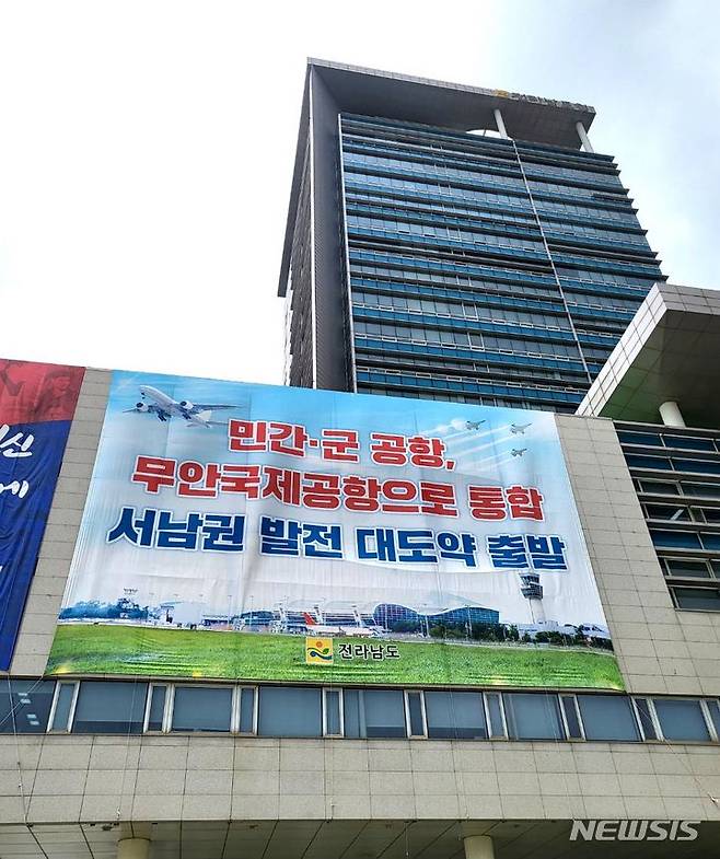 [무안=뉴시스] 이창우 기자=전남도청 청사 외벽에  '광주 민간·군공항의 무안국제공항 통합 이전'을 통한 선남권 발전 대도약 출발을 홍보하는 대형 현수막이 내걸려 있다. lcw@newsis.com