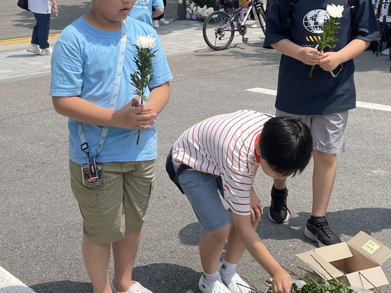 20일 서울 서초구의 한 초등학교 앞에 어린이가 국화꽃을 들고 추모하고 있다. 〈사진=JTBC 송혜수 기자〉