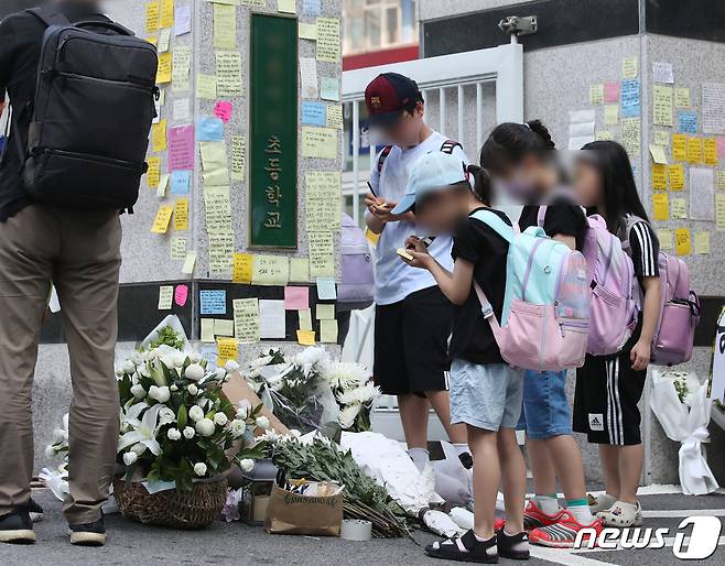 20일 오전 서울 서초구의 한 초등학교 정문에서 학생들이 추모 메시지를 적고 있다. 서울시교육청 등에 따르면, 지난 18일 오전 이 학교 1학년 담임인 A씨(23)가 극단적인 선택으로 사망하는 일이 발생했다. 2023.7.20/뉴스1 ⓒ News1 구윤성 기자