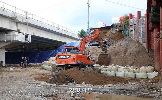 폭우로 인해 물에 잠긴 충북 청주 오송 지하차도에서 밤사이 시신 4구가 추가로 발견되며 사망자가 13명으로 집계된 가운데 17일 물이 범람한 미호천 인근에서 보수 작업이 이루어지고 있다. 권도현 기자