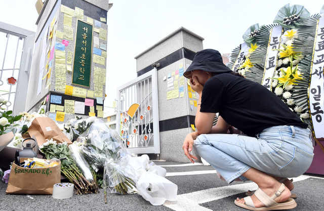 한 추모객이 초등학교 담임 교사가 극단적 선택을 하는 사건이 벌어진 서울 서초구 서이초등학교 정문 앞에서 20일 고인을 추모하고 있다. 최현규 기자