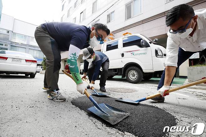 지난 2021년 7월15일 광주 북구 주택가 이면도로에서 북구 건설과 도로관리팀 직원들이 지난 집중호우로 생긴 포트홀 복구 작업을 하고 있다.(광주북구 제공)2021.7.15/뉴스1 ⓒ News1