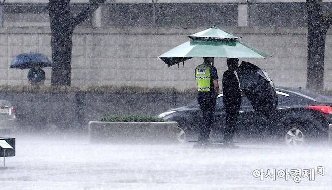 3일 서울 광화문광장 인근에서 경찰 근무자들이 쏟아지는 국지성 호우 속에 근무하고 있다. 기상청은 전국이 흐린 가운데 비가 내리겠고, 중부와 경북에는 최고 150mm의 국지성 호우가 쏟아진다고 예보했다./김현민 기자 kimhyun81@