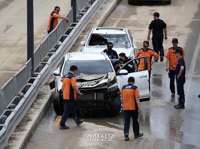 폭우로 인해 물에 잠긴 충북 청주 오송 지하차도에서 밤사이 시신 4구가 추가로 발견되며 사망자가 13명으로 집계된 가운데 17일 사고현장 지하차도에서 구조대원 등이 침수된 차량을 살펴보고 있다. 권도현 기자