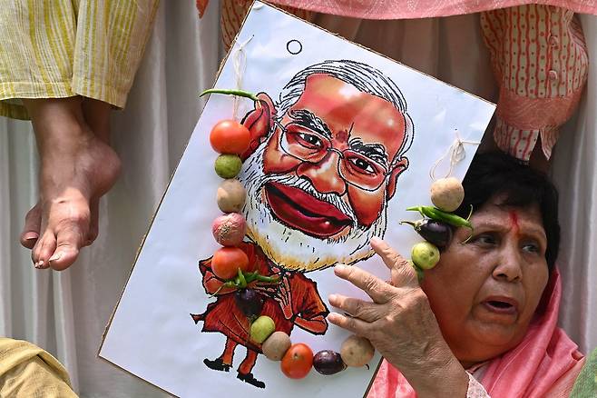 7월20일, 인도 마니푸르주의 소수 부족 여성에게 자행된 성폭력에 항의하는 시위에서 한 시민이 나렌드라 모디 총리의 캐리커처를 들고 있다. ⓒAFP PHOTO