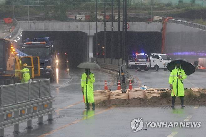 장맛비 뚫고 이어지는 유류품 수색 (청주=연합뉴스) 서대연 기자 = 18일 오전 미호천 제방 유실로 침수된 충북 청주시 오송읍 궁평2지하차도 수색구조현장에서 경찰 관계자들이 희생자 유류품 수색이 이어지고 있는 지하차도를 통제하고 있다, 2023.7.18 dwise@yna.co.kr