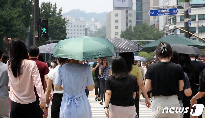 장마가 소강상태로 보이며 서울 일부 지역에 폭염경보가 발효된 20일 서울 종로구 세종대로 사거리에서 시민들이 양산을 쓴 채 발걸음을 옮기고 있다. 서울시는 20일 오전 10시 서울 동남권과 서남권 지역에 폭염경보가 발효됐다고 밝혔다. 올 여름철 첫 폭염경보 발령이다. 폭염경보는 일 최고체감온도 35도 이상인 상태가 2일 이상 지속될 것으로 예상될 때 내려진다. 2023.7.20/뉴스1 ⓒ News1 김성진 기자