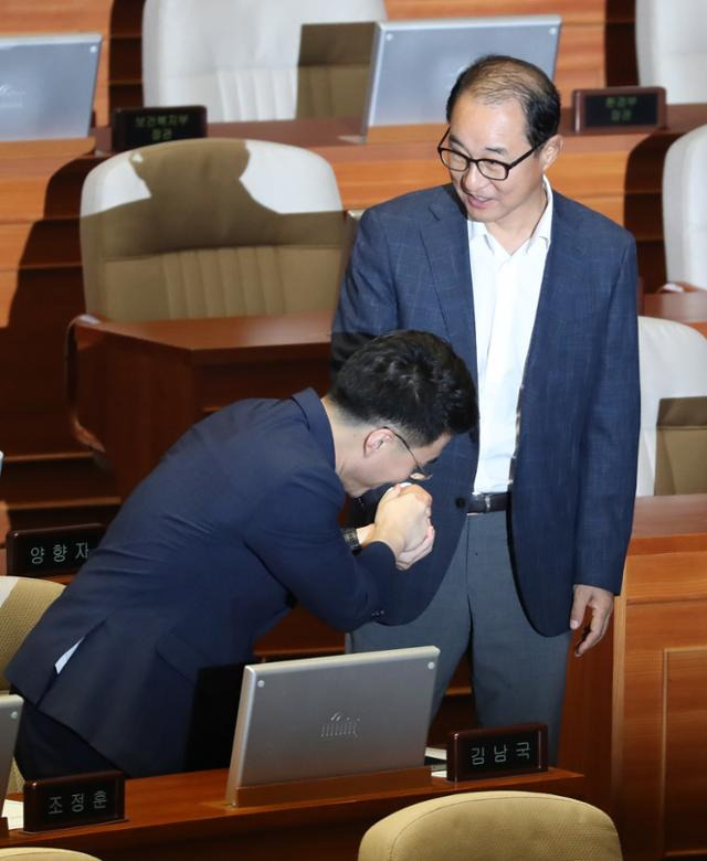 무소속 김남국(왼쪽) 의원이 이성만 의원과 18일 오후 국회 본회의장에서 인사를 나누고 있다. 뉴시스