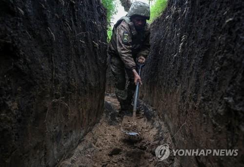 도네츠크 전선의 참호에서 진흙을 퍼내는 우크라 병사 [로이터 연합뉴스 자료사진. 재판매 및 DB 금지]