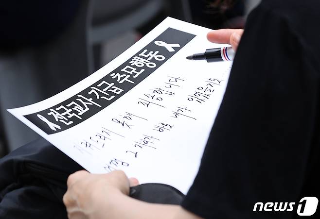 22일 오후 서울 중구 청계천에서 전국교직원노동조합 주최로 열린 서초구 서이초 교사 추모 집회에서 참가자들이 추모 메시지를 적고 있다. 2023.7.22/뉴스1 ⓒ News1 구윤성 기자