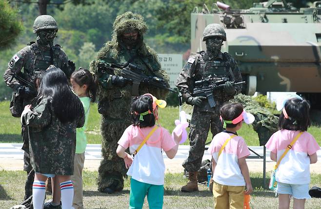 육군 제36보병사단 부대 개방 행사가 열린 17일 부대 연병장에서 어린이들이 위장한 군인들을 바라보고 있다.[사진제공=연합뉴스]