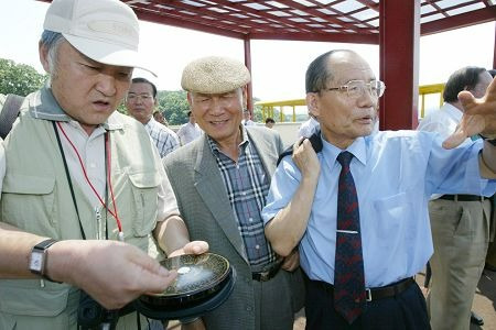 신행정수도 건설 추진위원회에 자문위원으로 참여한 풍수지리 전문가인 이대우 서문풍수조경연구소 대표(좌측)가 2004년 7월 28일 충남 연기군 남면(현 세종시) 부지를 둘러보며 나침반으로 조사하는 모습.