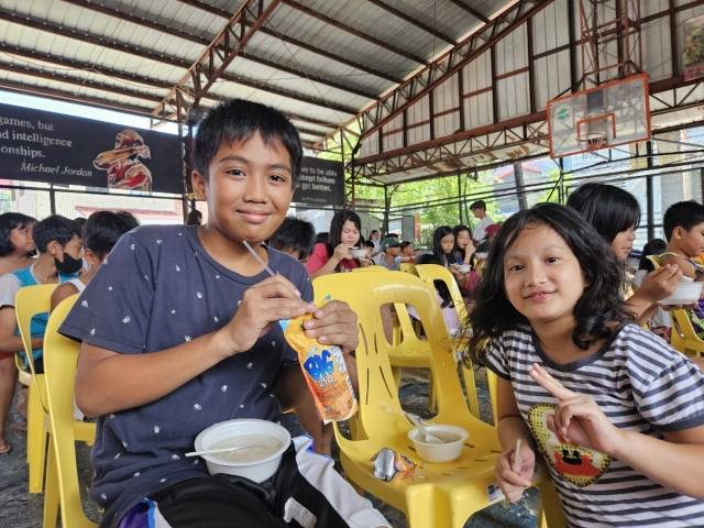 지난 18일 따뇽 중심가 다목적홀에서 만난 마테오 남매. 집과 건물 그림을 좋아하는 로이드 마테오(12)는 건축가가 되어 가족을 위한 집을 짓고 싶다고 말했다. 그의 여동생 프린베스 마테오(9)가 옆에 두 손가락으로 V를 그리고 있다. 필리핀 말라본시=이정헌 기자