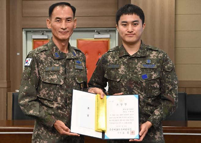 공군 제18전투비행단장 오홍균 준장이 이현규 병장과 기념 촬영을 하고 있다. 18전비 제공