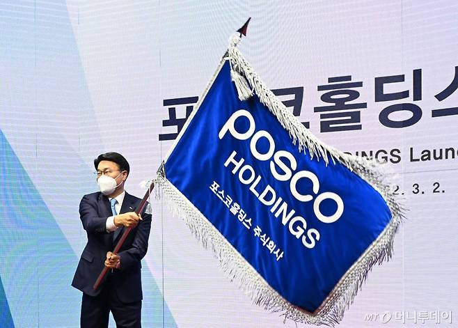 포스코홀딩스 출범식에서 포스코그룹 최정우 회장이 사기(社旗)를 흔들고 있다.