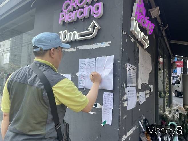 지난 21일 발생한 신림역 칼부림 사건의 피해자를 위해 22일 추모 공간이 설치됐다. 사진은 추모 공간 한켠에서 피해자를 향한 추모의 글을 남기는 시민. /사진=정유진 기자