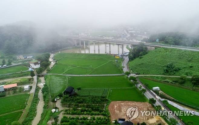 '이곳이 대안 노선의 종점 양평군 강상면 병산리' (양평=연합뉴스) 김도훈 기자 = 14일 오후 서울-양평 고속도로 대안 노선의 종점인 경기도 양평군 강상면 일대 모습.
    대안노선에 따르면 서울-양평고속도로는 이 일대에서 교각 위로 지나는 중부내륙고속도로와 연결될 계획이었다.
    교각 위 도로가 중부내륙고속도로이며 왼쪽은 남양평IC 방면, 오른쪽은 양평대교 방면. 2023.7.14 superdoo82@yna.co.kr