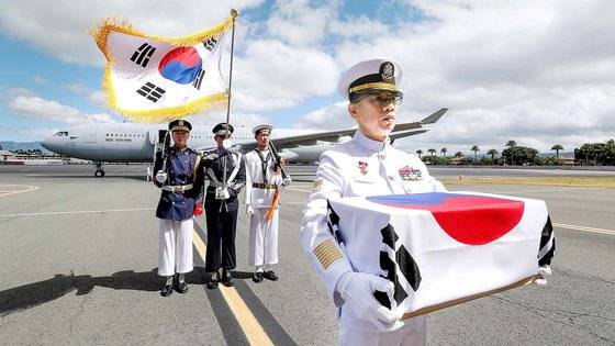 25일(현지시간) 미국 하와이 히캄 공군기지에서 열린 국군전사자 유해 인수식에서 국군전사자 고 최임락 일병의 유해를 유가족(조카)인 최호종 해군 상사가 봉송하는 모습. 사진 국방일보.