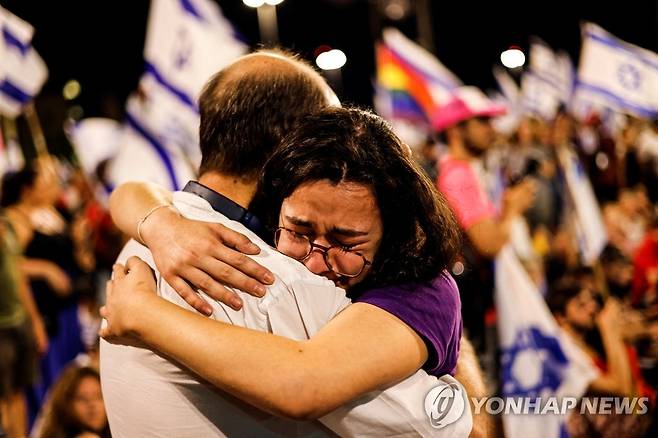 끌어안는 이스라엘 '사법 정비' 반대 시위 참가자들 (예루살렘 로이터=연합뉴스) 이스라엘 '사법 정비' 반대 시위 참가자들이 24일(현지시간) 예루살렘 의회 인근에서 서로를 끌어안고 있다. 이날 이스라엘 의회인 크네세트는 격렬한 저항에도 불구하고 집권 연정이 발의한 사법부 권한 축소 법안 처리를 강행했다. 2023.07.25 clynnkim@yna.co.kr