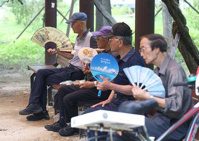 경남 창원지역에 폭염경보가 발효된 지난 26일 오후 마산합포구 3·15해양누리공원에서 시민들이 부채질하고 있다. 연합뉴스.