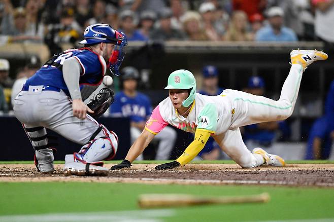 김하성(오른쪽)이 29일 MLB(미 프로야구) 텍사스 레인저스와의 홈 경기(미 캘리포니아주 샌디에이고 펫코 파크)에 1번 타자 겸 2루수로 선발 출전해 6회말 홈을 향해 헤드 퍼스트 슬라이딩을 시도하고 있다. /AFP연합뉴스