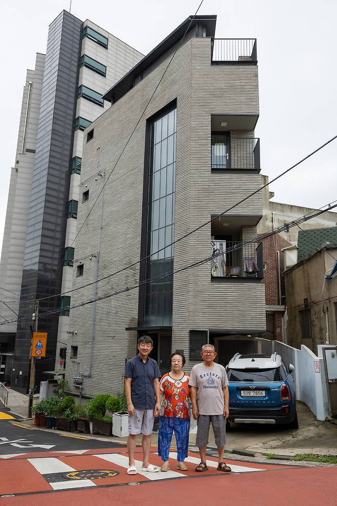 2023년 7월15일 서울 성동구 마장동 협소주택 앞에서 아들이자 건축주인 곽석준씨(맨 왼쪽)가 부모님 노기남(가운데)·곽재환(맨 오른쪽)씨와 함께 서 있다. 박승화 기자