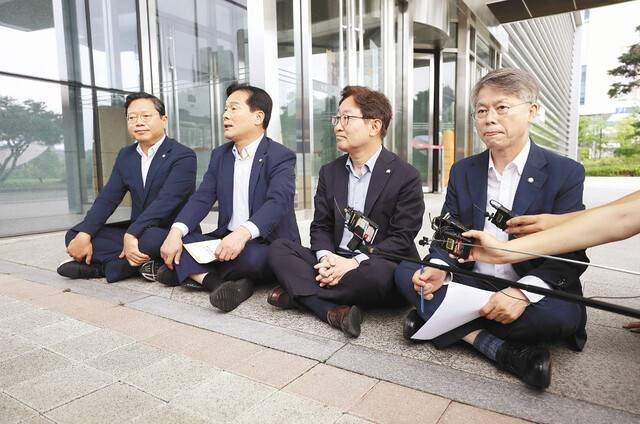 더불어민주당 김승원·주철현·박범계·민형배 의원(왼쪽부터)이 지난 24일 이화영 전 경기부지사에 대한 수사와 관련해 수원지검을 항의 방문했다가 지검장과의 면담이 불발되자 청사 앞에 앉아 취재진에게 입장을 밝히고 있다. 연합뉴스