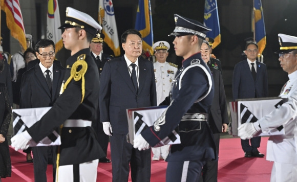 Koreas War Anniversary - ·윤석열 대통령이 26일 오후 경기 성남 서울공항에 도착한 6·25 전쟁 국군전사자 유해 앞에 참석자들과 함께 도열하고 있다.-AP 연합뉴스