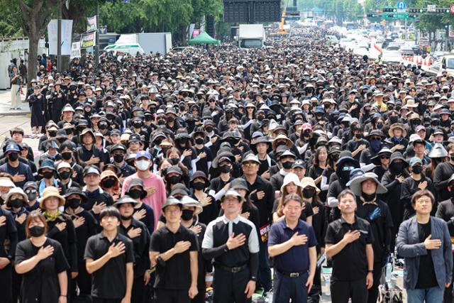 서이초 교사를 추모하기 위해 전국 각지에서 모인 교사들이 29일 서울 종로구 경복궁역 사거리 인근에서 국민의례를 하고 있다. 연합뉴스