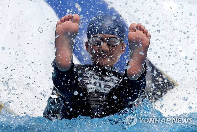 '이것이 여름' (서울=연합뉴스) 류영석 기자 = 서울, 경기 등 중부지방에 폭염경보가 발효 중인 30일 오후 '2023 서울썸머비치' 물놀이장이 마련된 서울 광화문광장에서 한 어린이가 미끄럼틀을 타고 있다. 2023.7.30 ondol@yna.co.kr