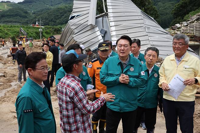 윤석열 대통령이 지난달 17일 경북 예천군 감천면 벌방리를 찾아 산사태 피해 현황에 대한 설명을 듣고 있다. [연합]