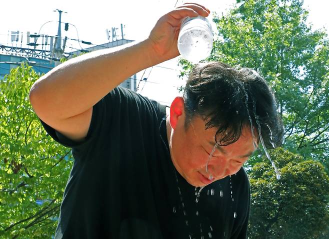 전국에 폭염특보가 발효된 2일 광주 북구 우산근린공원에서 자율방재단과 북구청 직원들이 준비한 얼음물을 한 시민이 머리에 붓고 있다. /뉴스1