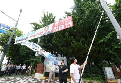 이달 12일 오전 인천시 연수구 소금밭사거리에서 연수구청 관계자들이 시 조례 위반 정당 현수막을 강제 철거하고 있다. 사진=연합