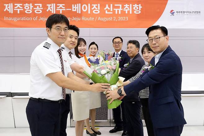 2일 제주국제공항에서 열린 제주항공 ‘제주~베이징 노선 신규취항식’에 참석한 한상수 제주항공 제주운영단장(오른쪽 맨 앞) 등 관계자가 승무원들에게 꽃다발을 전하고 있다. (사진=제주항공)