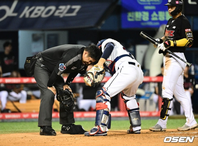 김선수 주심이 6회초 무사 1루 상황에서 KT 문상철의 파울 타구에 맞은 뒤 고통스러워하고 있다.