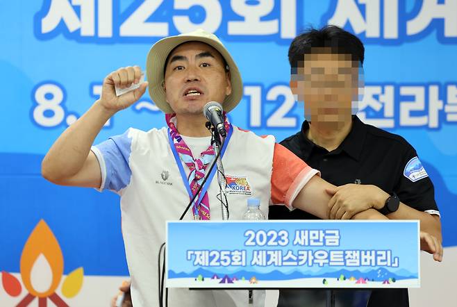 6일 2023 세계스카우트잼버리 프레스센터에서 한국스카우트연맹 김태연 전북연맹 스카우트 제900단 대장이 기자회견을 열고 영내에서 성범죄가 발생해 퇴소하겠다고 밝히는 가운데 조직위 관계자가 만류하고있다. 2023.8.6/연합뉴스