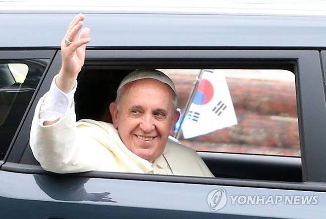 방한 일정을 마무리한 프란치스코 교황이 2014년 8월 18일 오전 서울공항 앞에서 배웅하는 시민들을 향해 손을 흔들고 있다. ⓒ연합뉴스