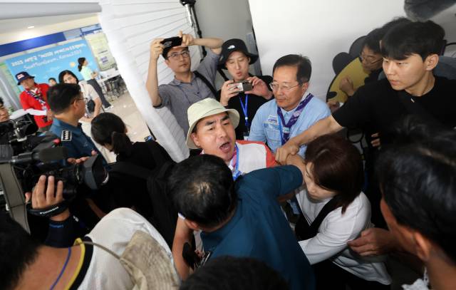 ▲6일 2023 새만금 세계스카우트잼버리 프레스센터에서 열린 브리핑 도중 "영내에서 성범죄가 발생했다"고 주장한 스카우트 지도자가 항의하다가 경찰과 조직위원회에 끌려 나가고 있다. ⓒ연합뉴스