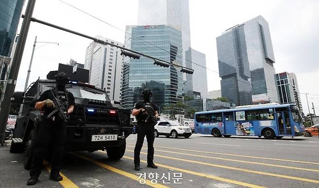 Due to a series of stabbings, armed members of the Police Special Operation Unit stand on guard in front of an armored vehicle at the Gangnam Station intersection in Seoul on August 6, a Sunday. Su Sung-il, Senior Reporter