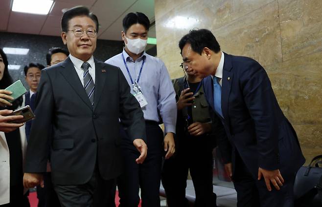 무소속 윤관석 의원이 12일 오전 국회에서 민주당 의원총회에 참석하는 이재명 대표에게 인사하고 있다. 윤 의원은 의총에 참석하는 의원들에게 인사하기 위해 기다리고 있었다. ⓒ연합뉴스
