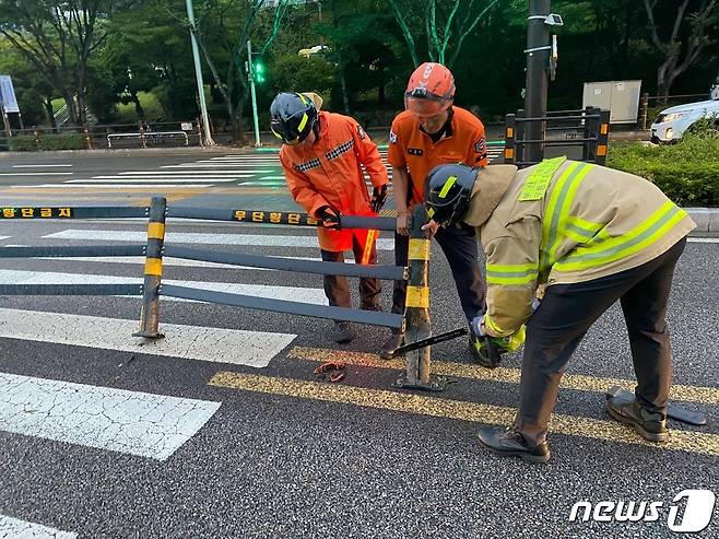 9일 오후 7시께 부산 해운대구 우동 한 도로에 설치된 중앙선 펜스가 쓰려져 소방이 안전조치를 하고 있다.(부산소방재난본부 제공)