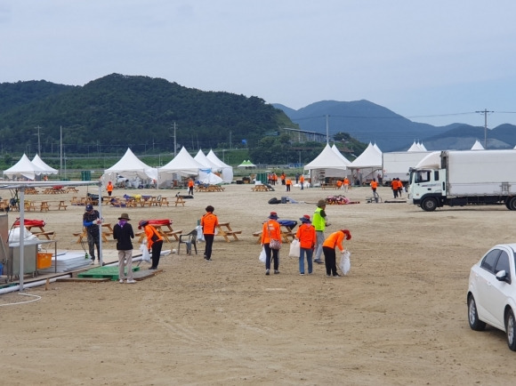 전북도청 공무원, 유관기관, 대기업 자원봉사자들이 새만금잼버리 영지 쓰레기 수거 활동을 펼치고 있다.