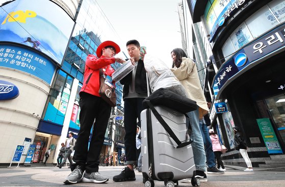 서울 명동 거리에서 중국인 관광객들이 관광 안내를 받고 있다. 연합뉴스