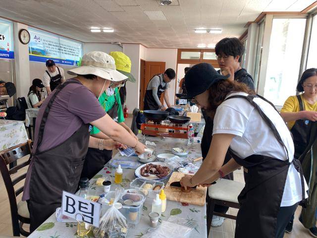 추봉도 주민들이 한국해양소년단과 함께 마련한 어촌체험프로그램 참가자들이 직접 잡은 해산물로 요리를 하고 있다. 한국해양소년단경남남부연맹 제공