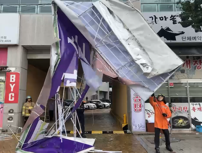 8.10.(목) 오후, 전남 화순군 화순읍 향청리에서 강풍으로 건물 간판이 떨어지면서 전선에 걸려 출동한 소방대원들이 안전조치를 하고 있다.