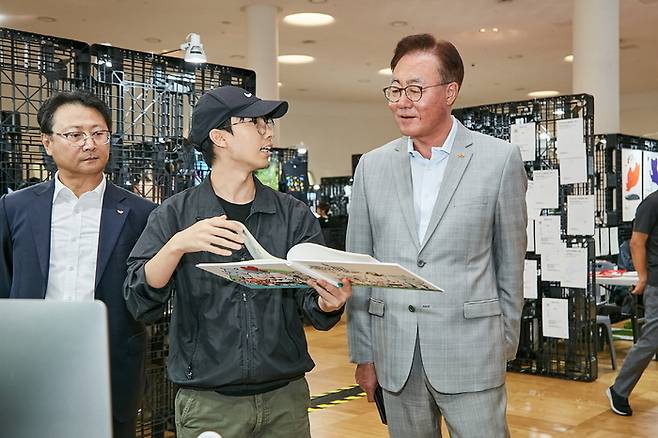 김준 SK이노베이션 부회장(맨오른쪽)이 10일 동대문 행복그린디자인 전시회를 찾아 출품작을 보며 학생·교수진과 의견을 나누고 있다. SK이노베이션