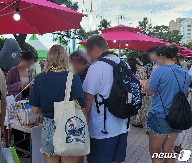 12일 부산 수영구 광안리해수욕장 일대에 열린 '광안아트마켓'에서 잼버리 대원들이 그림을 구경하고 있다.2023.8.12/뉴스1 ⓒ News1 조아서 기자